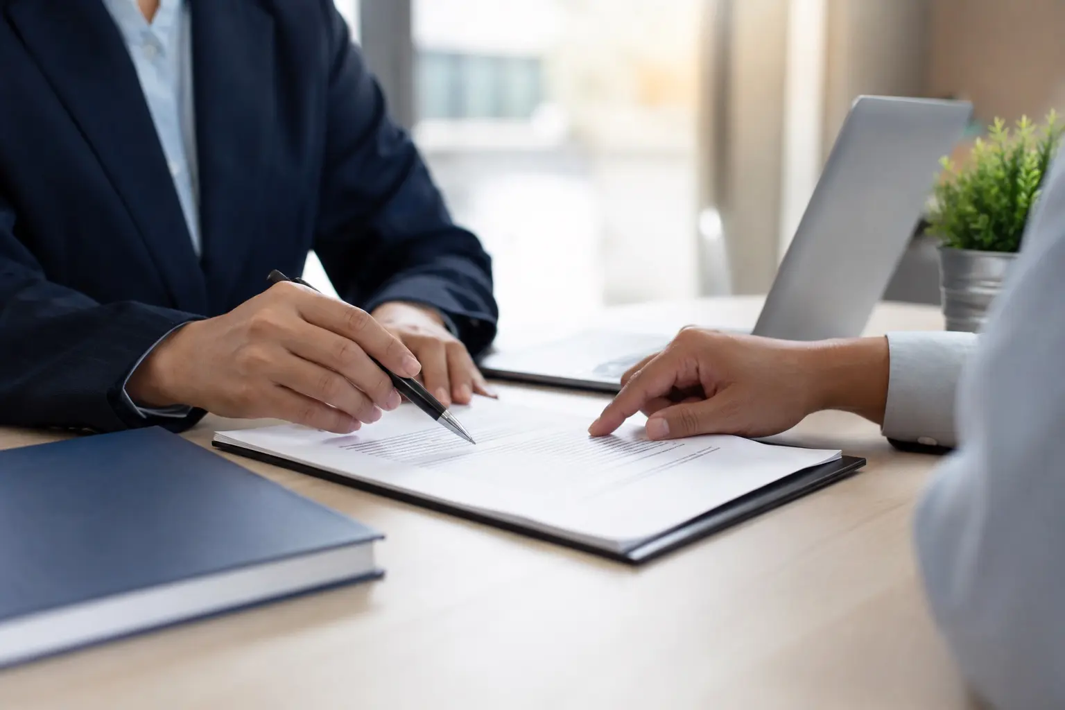 Dos personas revisando un documento laboral sobre una mesa de oficina, ambiente profesional y equilibrado